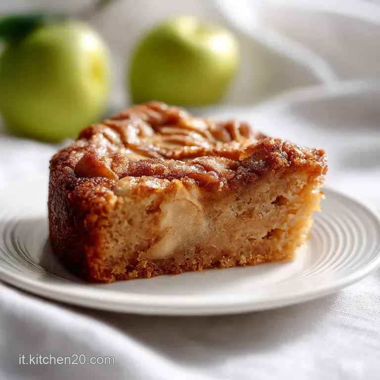 Elegant slice of spiced apple cake on a white plate, adorned with a dollop of cream.